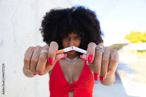beautiful afro american woman breaking a cigarette and looking at the camera. Campaign on smoking cessation awareness. Health concept. Smoke-free world photo