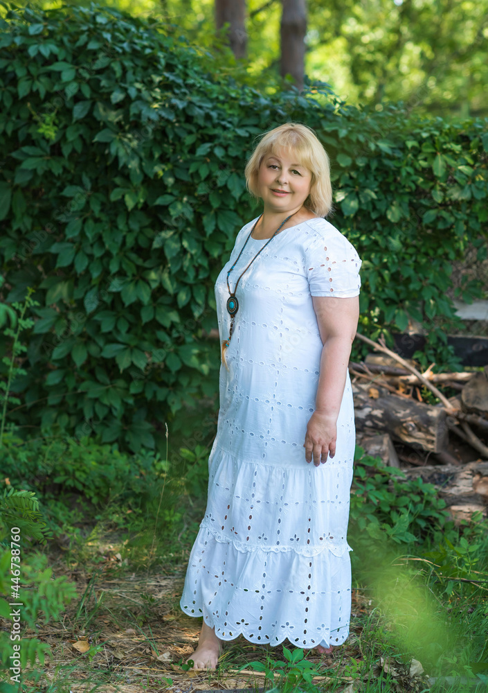 Fototapeta premium Portrait of attractive plus size mature woman in casual style walk at good sunny day. Life of women after 40-50 years