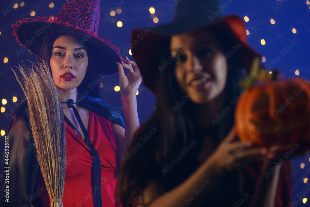Cheerful woman in witch hat showing Halloween pumpkin Cheerful woman in witch hat showing Halloween pumpkin