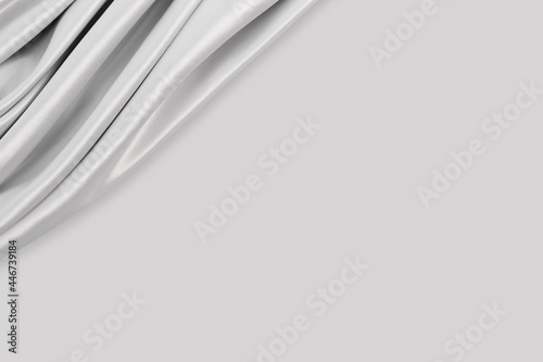 Beautiful elegant wavy silver white satin or grey silk luxury cloth fabric texture with monochrome background design. Copy space. 