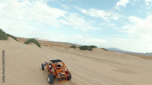 Orange Dune Buggy Driving in the Desert Sand Dunes photo