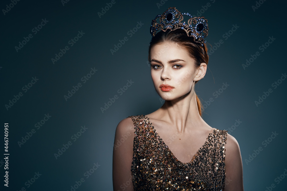 attractive woman in a golden dress with a crown on her head decoration studio