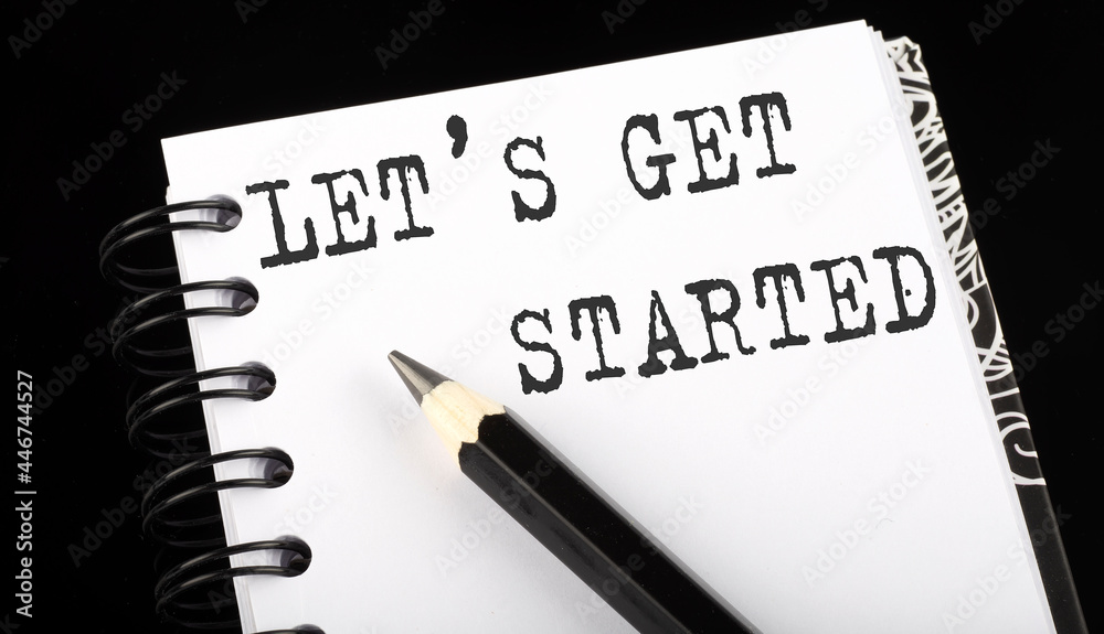 Obraz premium LET'S GET STARTED written text in small notebook on a black background