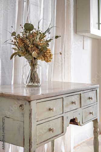 A bouquet of dry flowers in a hallway of the retro style apartment with vintage furniture.