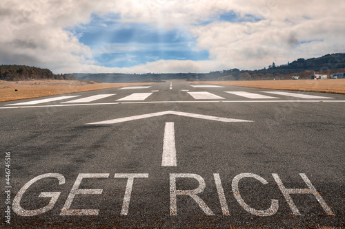 White arrow on a small asphalt air plane runway. Cloudy sky with