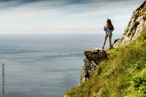 Teenager girl in a mountains  enjoys great view on the ocean