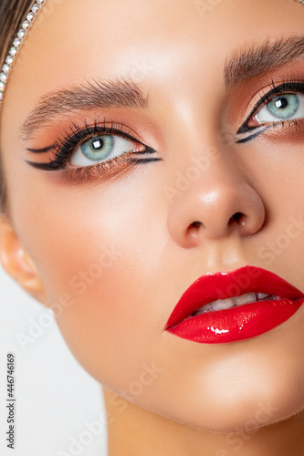 Beautiful girl - eye makeup with arrows. the beauty. Fashion Beauty Portrait retro style make-up - red lips, black arrows. closeup. Red lips 