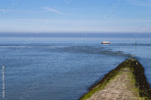 The photo shows a land pier with a survey vessel during the day on the island of Baltrum