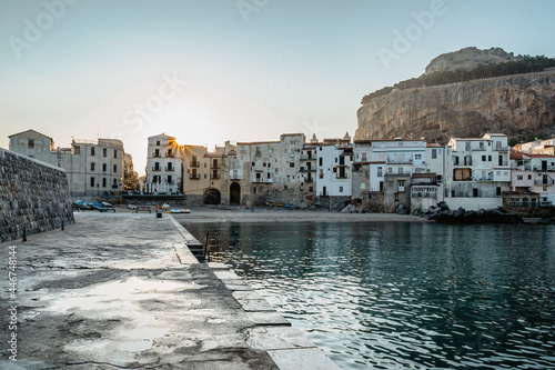 Sunrise on beach in Cefalu, Sicily, Italy, old town panoramic view with colorful waterfront houses, sea and La Rocca cliff.Attractive summer cityscape,traveling concept background.Italian vacation
