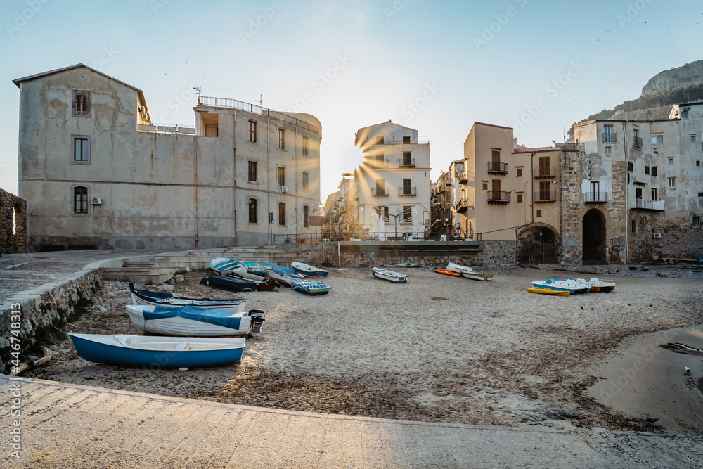 Beautiful old harbor with wooden fishing boats,colorful waterfront stone houses and sandy beach in Cefalu, Sicily, Italy.Attractive summer cityscape,traveling concept background.Italian vacation.
