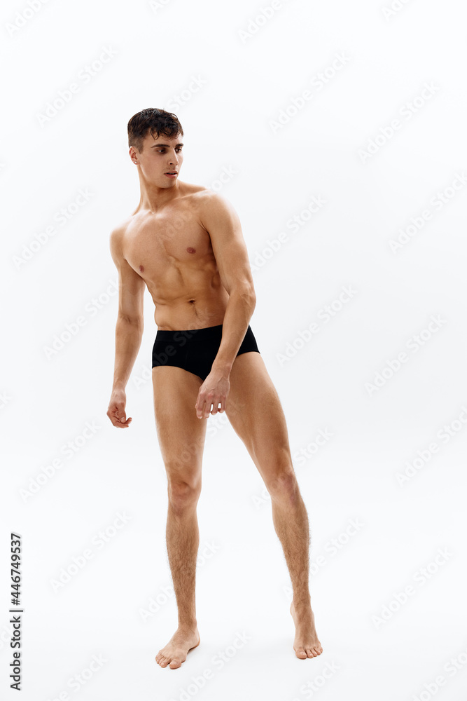 sexy male bodybuilder in dark shorts fitness light background