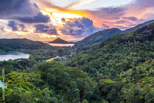 Mahe Island coast drone sunset landscape with dramatic pink sky, clouds, lush tropical forest and small islands around. photo