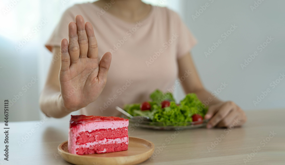 Diet concept. Women refuse cake and eat salad for good health.