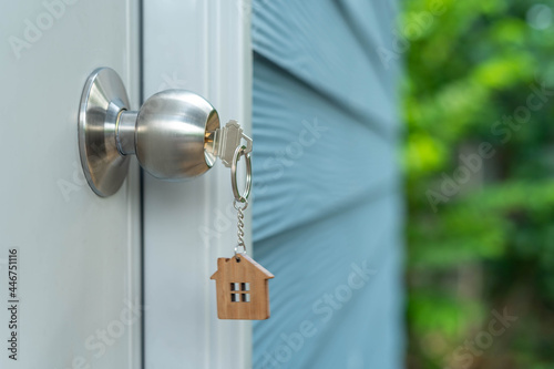 The house key is inserted in the door. Selling and renting a house concept © Shisu_ka