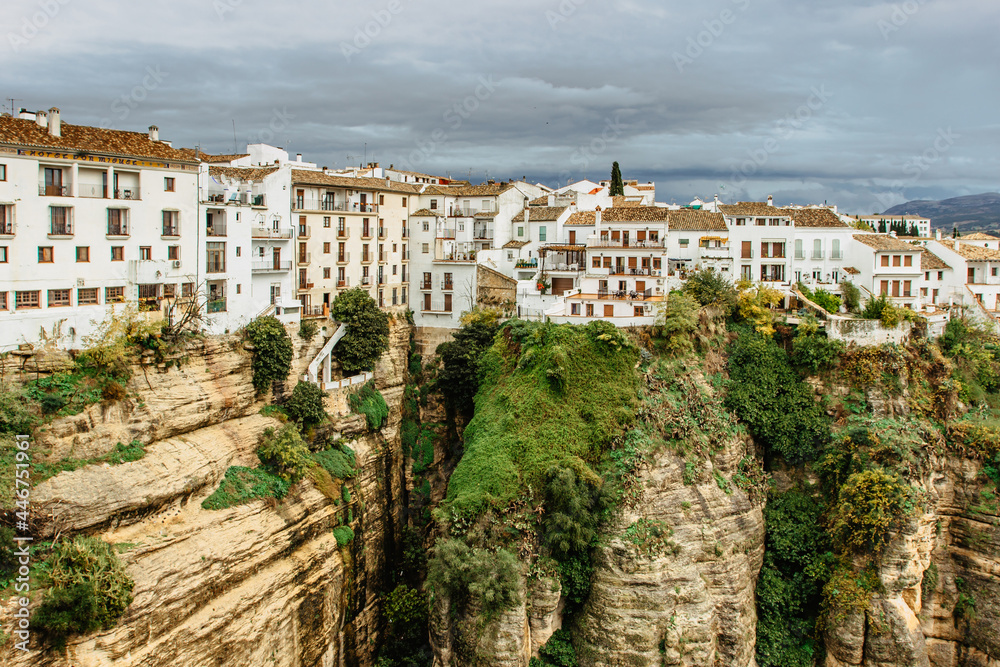 Ronda, Andalucia. Landscape of white houses on the edge of steep cliffs surrounded by mountains. Village panorama.View of the Tajo canyon. Holiday urban concept.Popular tourist destination in Spain.