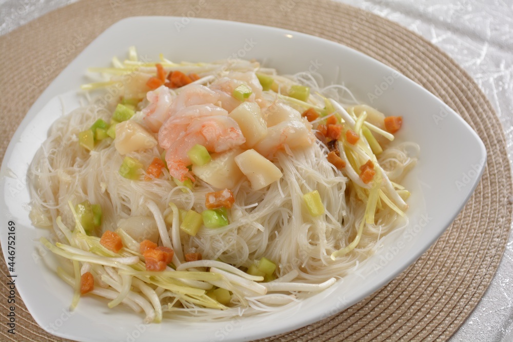 braised wok fried bee hoon vermicelli thin noodle with seafood prawn scallop and vegetables in chef white sauce in white background asian halal menu braised wok fried bee hoon vermicelli thin noodle with seafood prawn scallop and vegetables in chef white sauce in white background asian halal menu