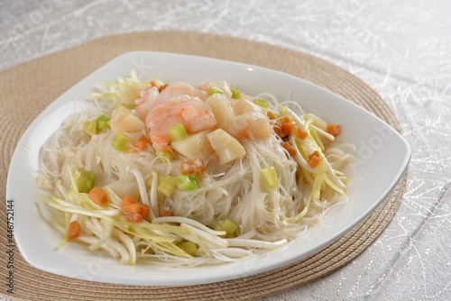 braised wok fried bee hoon vermicelli thin noodle with seafood prawn scallop and vegetables in chef white sauce in white background asian halal menu