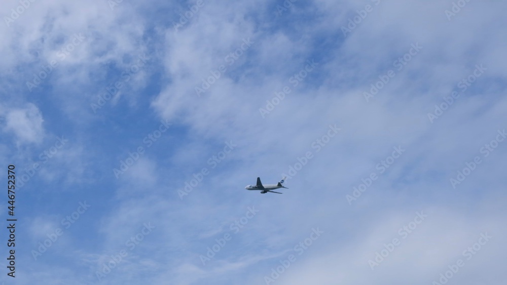 Silhouette Modern large plane flies in the sky. Beautiful blue sky and white clouds in the background. The aircraft flies overhead. Airplane takes off or landing Silhouette Modern large plane flies in the sky. Beautiful blue sky and white clouds in the background. The aircraft flies overhead. Airplane takes off or landing