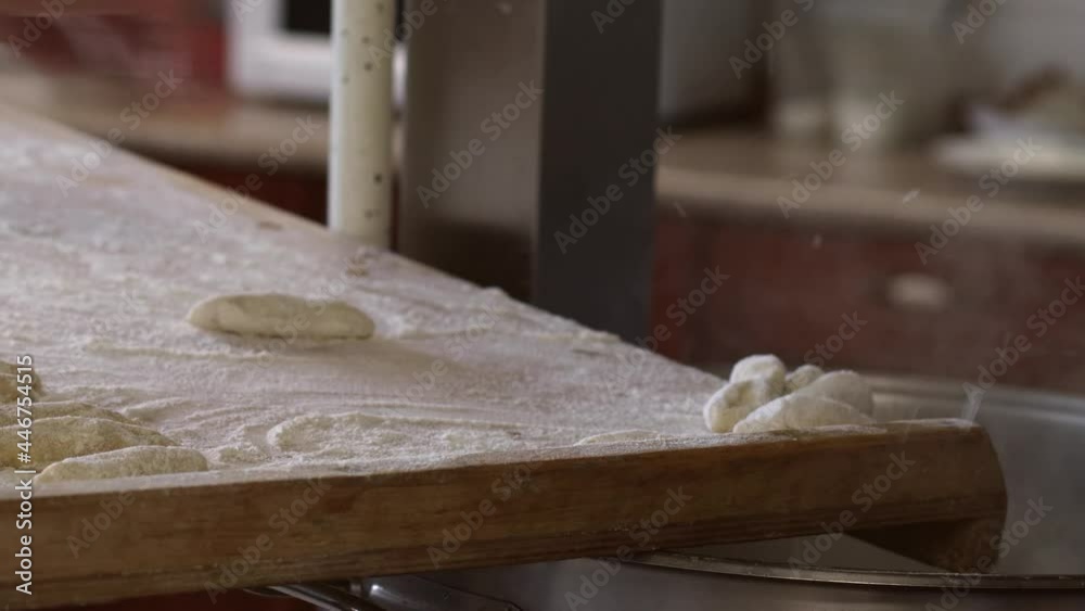 The cook throws his hand sticks of dough rolled in flour in a saucepan with boiling water. The cook throws his hand sticks of dough rolled in flour in a saucepan with boiling water.