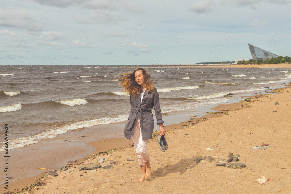 the girl walks on a sandy beach along the sea