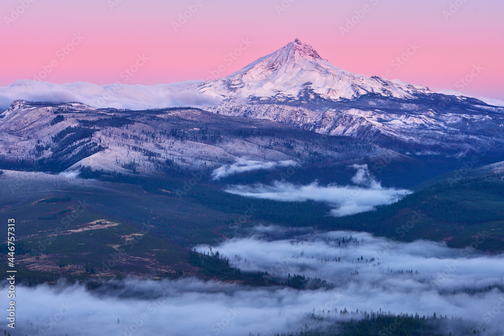 Mountain sunrise with Mt Jefferson covered by fresh snow and fog in the valley in late autumn.