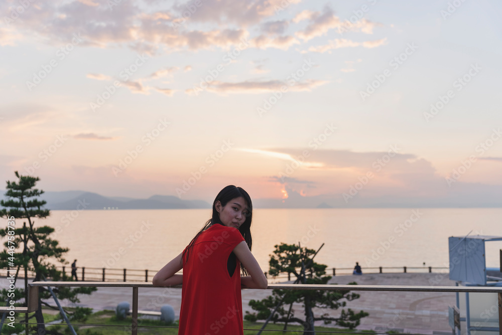 Fototapeta premium 夕暮れの海にいる女性