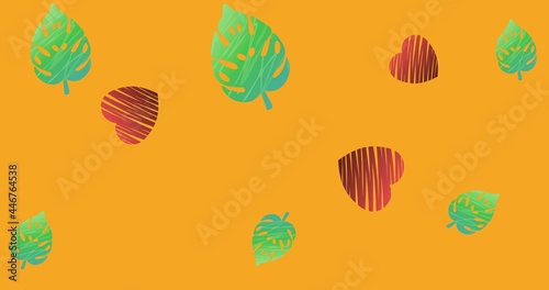 Composition of green leaves and red hearts on orange background