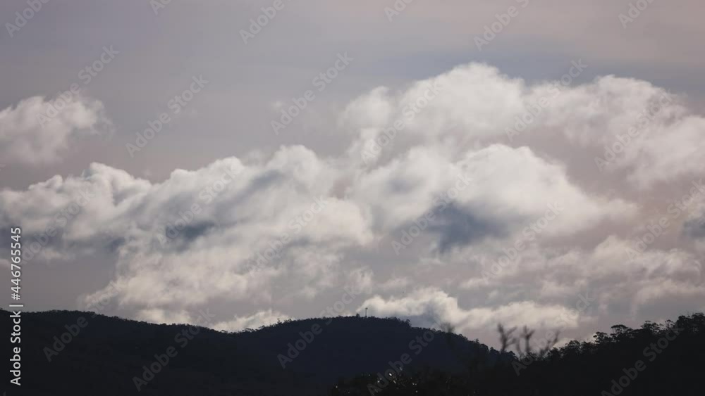 timelapse of clouds formation coming and going across a stormy sky shot iwith mountains and hills in the foreground