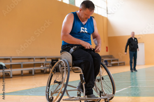 a handicapped basketball player prepares for a match while sitting in a wheelchair.preparations for a professional basketball match. the concept of disability sport