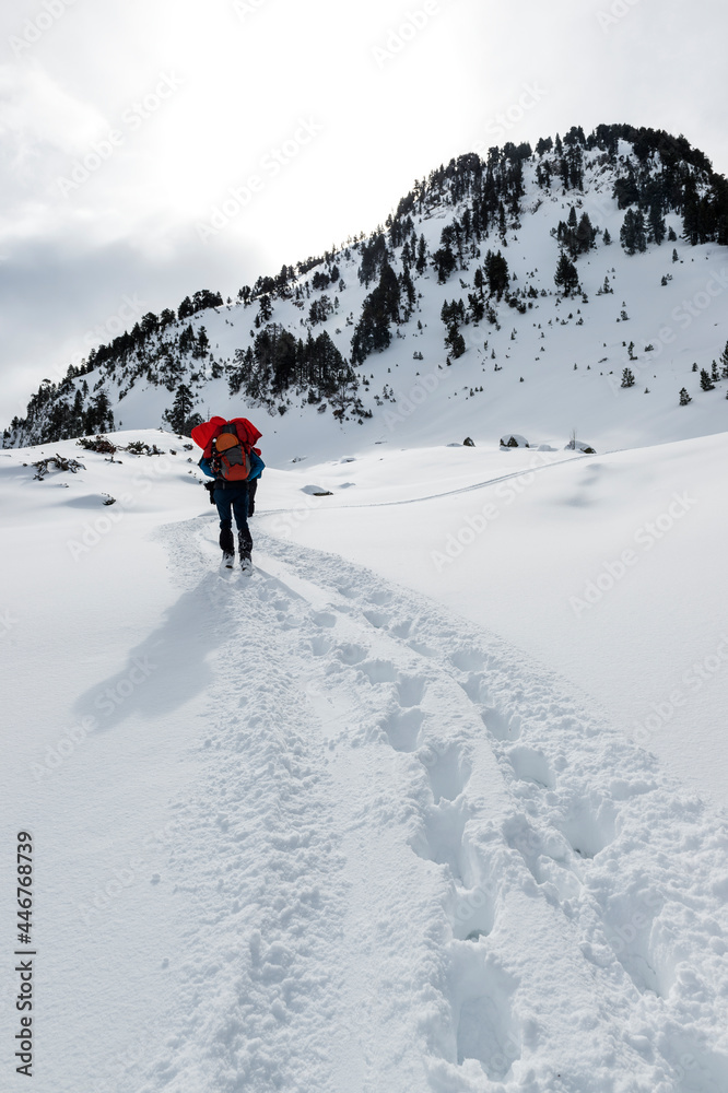 hiker walking up the snowy mountain