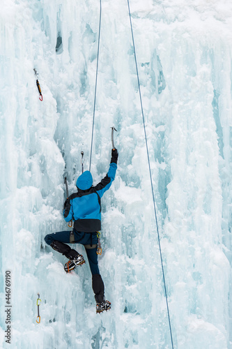 climber climbing a frozen waterfall