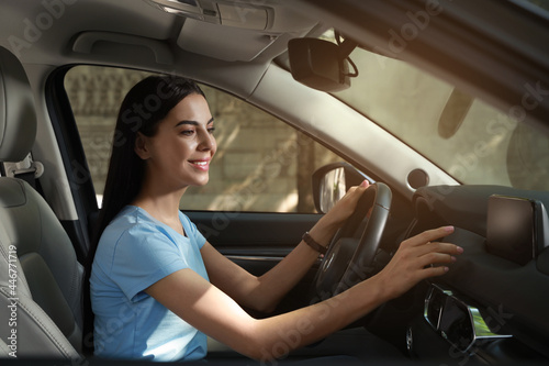 Young woman using navigation system while driving car