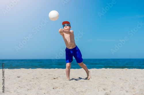 Young boy playing volleyball on beach. Summer sport concept.