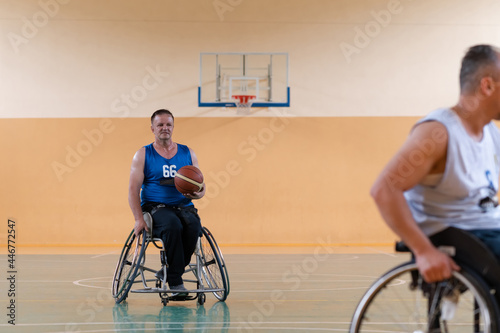 disabled war veterans in action while playing basketball on a basketball court with professional sports equipment for the disabled © .shock