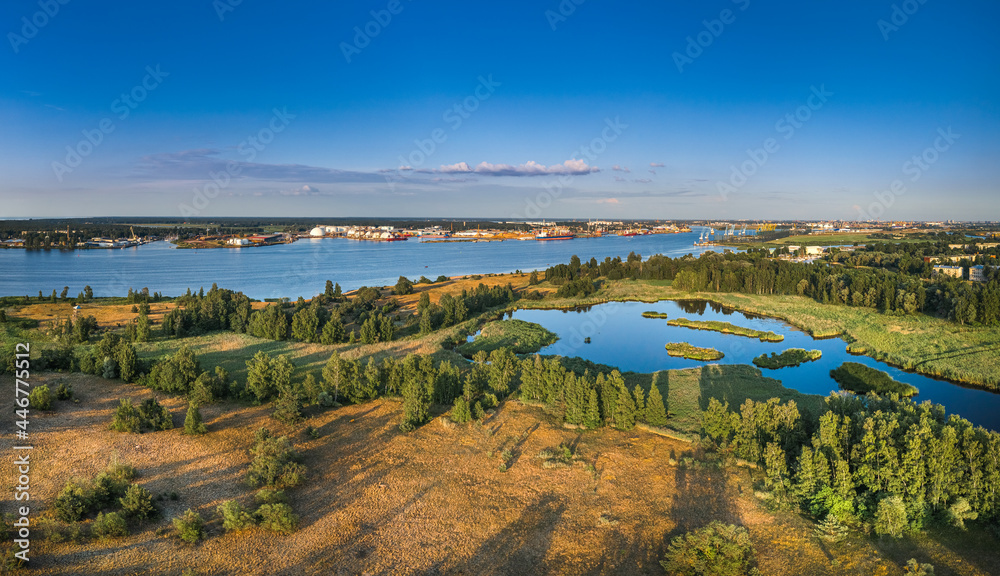 Riga port loading terminal with container ships. Boats and yachts riding on river. Industrial territory meets sustainable environment.
Riga port loading terminal with container ships. Boats and yachts riding on river. Industrial territory meets sustainable environment.