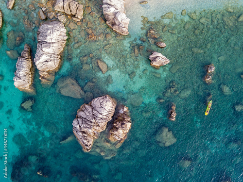 Aerial view of a canoe in the water floating on a transparent sea. Bathers at sea.Parghelia, Tropea, Calabria, Italy. Diving relaxation and summer vacations. Italian coasts, beaches and rocks photo