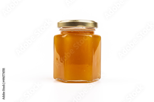 Glass jar full of sweet honey isolated on white background