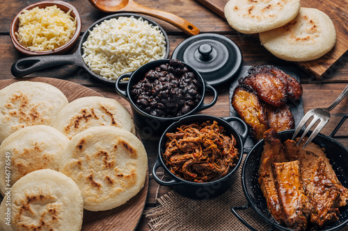 Table served with Venezuelan breakfast, arepas with different types of fillings such as black beans, shredded meat, fried plantain and cheese