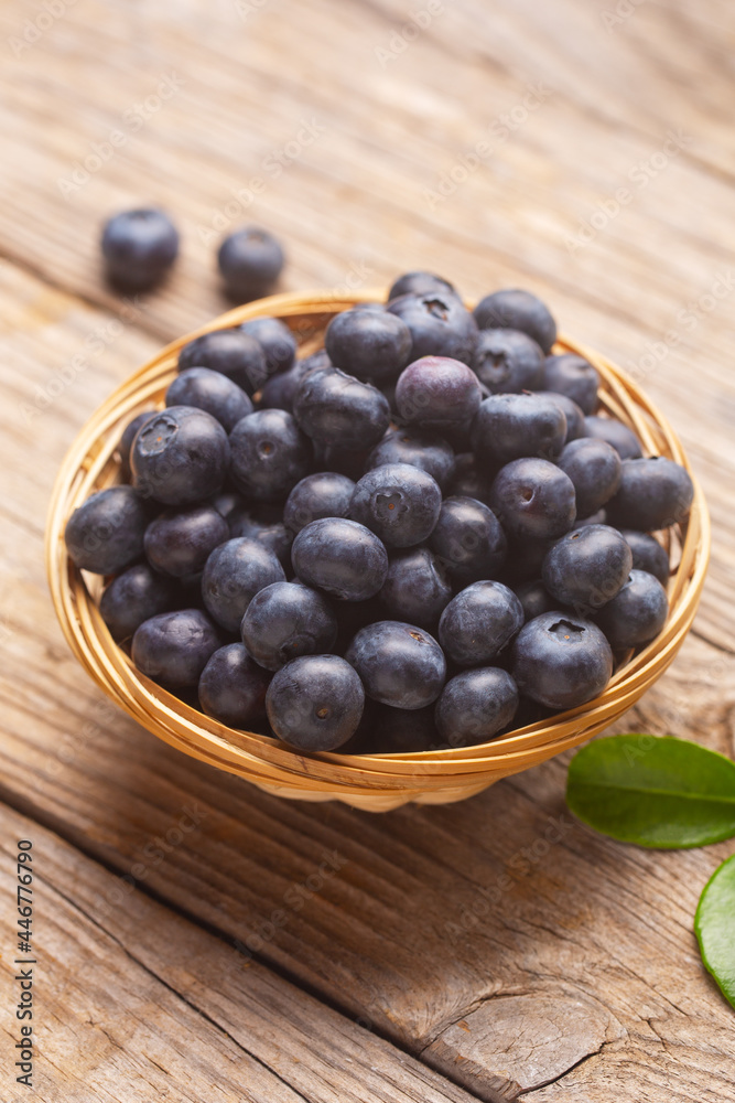 Organic blueberries in a wicker bowl with leaves Organic blueberries in a wicker bowl with leaves