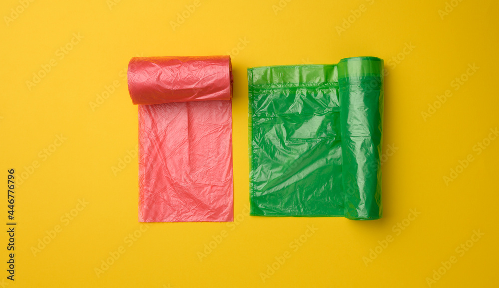 green and red plastic bags for trash can on yellow background