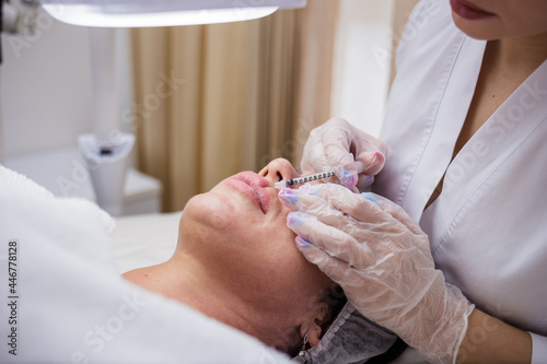 Wallpaper Mural a close-up of the doctor makes an increase in the lips of the client. Introduction of hyaluronic acid to the client Torontodigital.ca