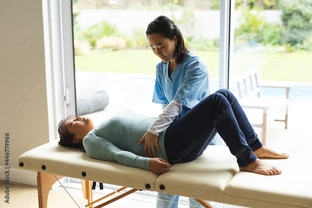 Asian female physiotherapist treating senior female patient at her home Asian female physiotherapist treating senior female patient at her home