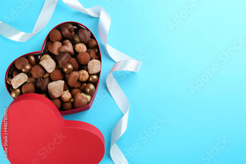 Different delicious chocolate candies in heart shaped box and ri © New Africa