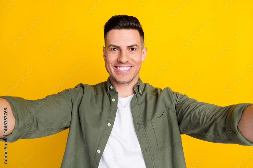 Photo portrait man smiling happy taking selfie isolated vibrant yellow color background Photo portrait man smiling happy taking selfie isolated vibrant yellow color background