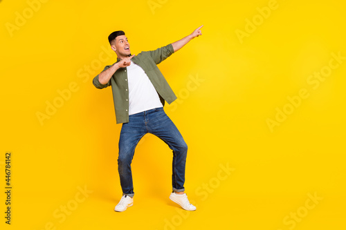Full length body size view of attractive cheerful guy dancing having fun relax isolated over bright yellow color background