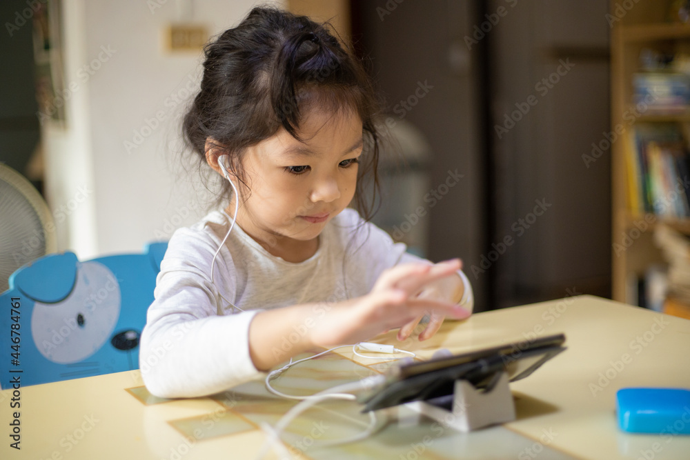 Asian girl learning the alphabets at home. New normal. Covid-19 coronavirus. Social distancing. stay home Asian girl learning the alphabets at home. New normal. Covid-19 coronavirus. Social distancing. stay home