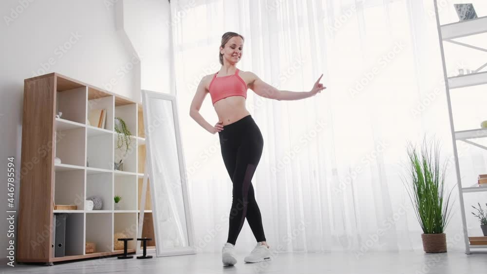 Dance classes. Choreography hobby. Artistic lifestyle. Home workout. Graceful happy athletic young woman in sportswear practicing in light apartment interior. Dance classes. Choreography hobby. Artistic lifestyle. Home workout. Graceful happy athletic young woman in sportswear practicing in light apartment interior.