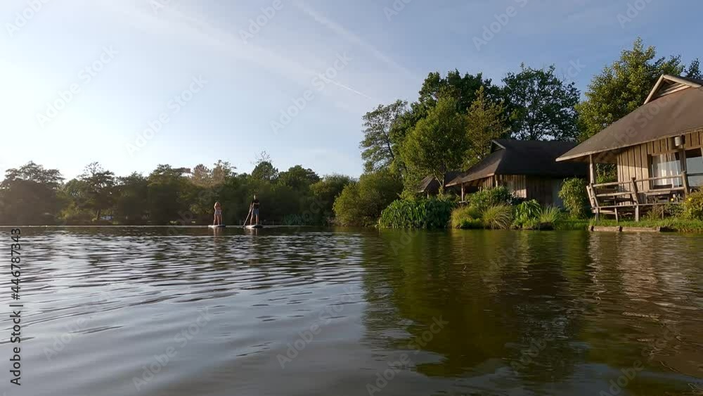 young couple paddle boarding at sunset young couple paddle boarding at sunset