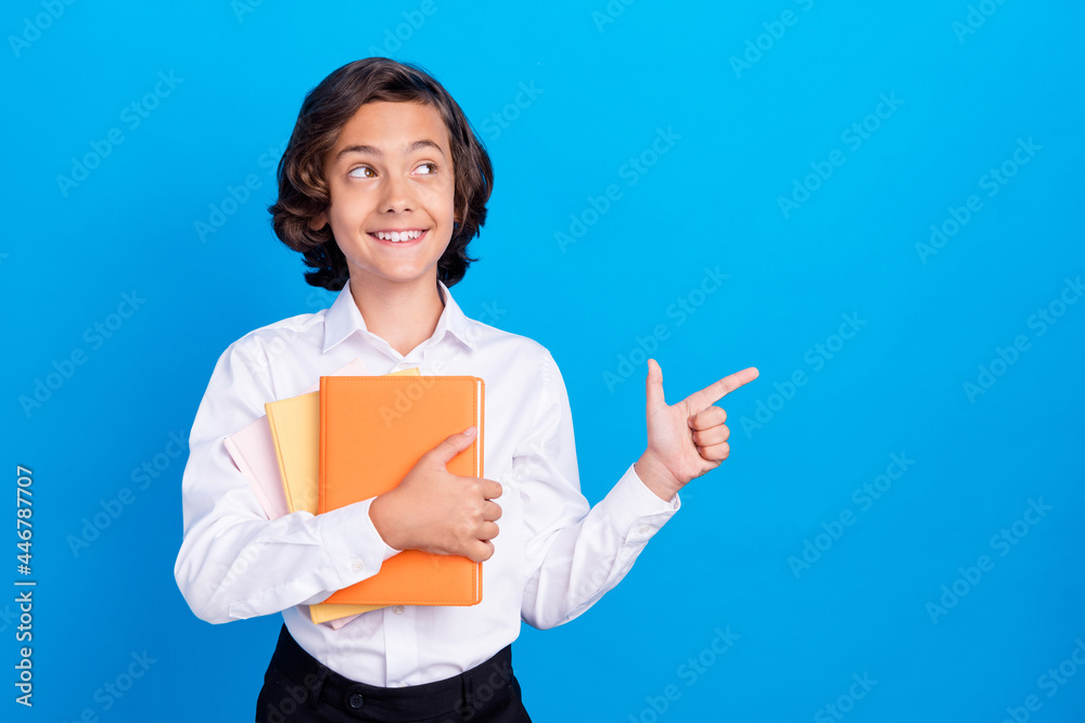 Photo of funny dreamy school boy wear formal outfit smiling looking pointing empty space isolated blue color background Photo of funny dreamy school boy wear formal outfit smiling looking pointing empty space isolated blue color background