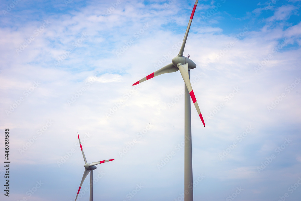 Two Wind turbines with blue sky background summer day.An environmentally friendly way to get electricity. Two Wind turbines with blue sky background summer day.An environmentally friendly way to get electricity.